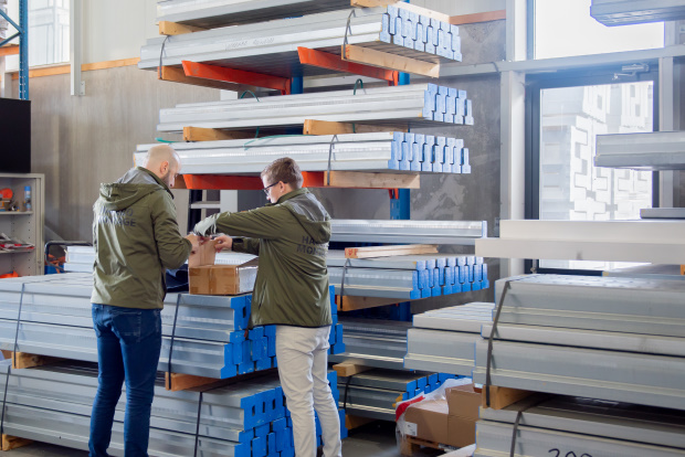 Medewerkers in een opslag gevuld met lichtgewicht stalen liggers.