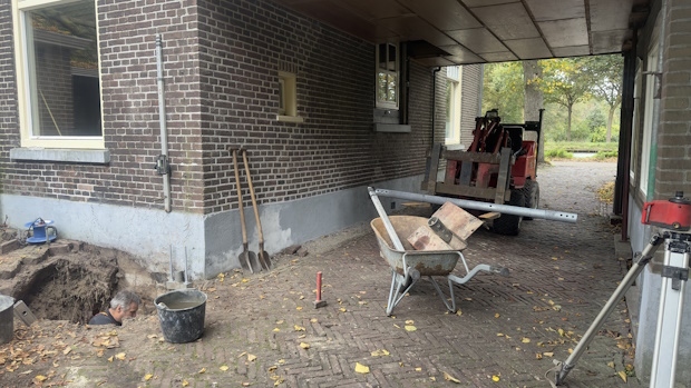 Uit onderzoeken bleek dat overal onder de woning de fundering hersteld moest worden. Hier wordt de eerste paal als test in de grond gedraaid.