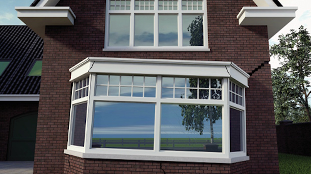 Brick house with a white-framed bay window extending from the first floor, reflecting trees and blue sky.